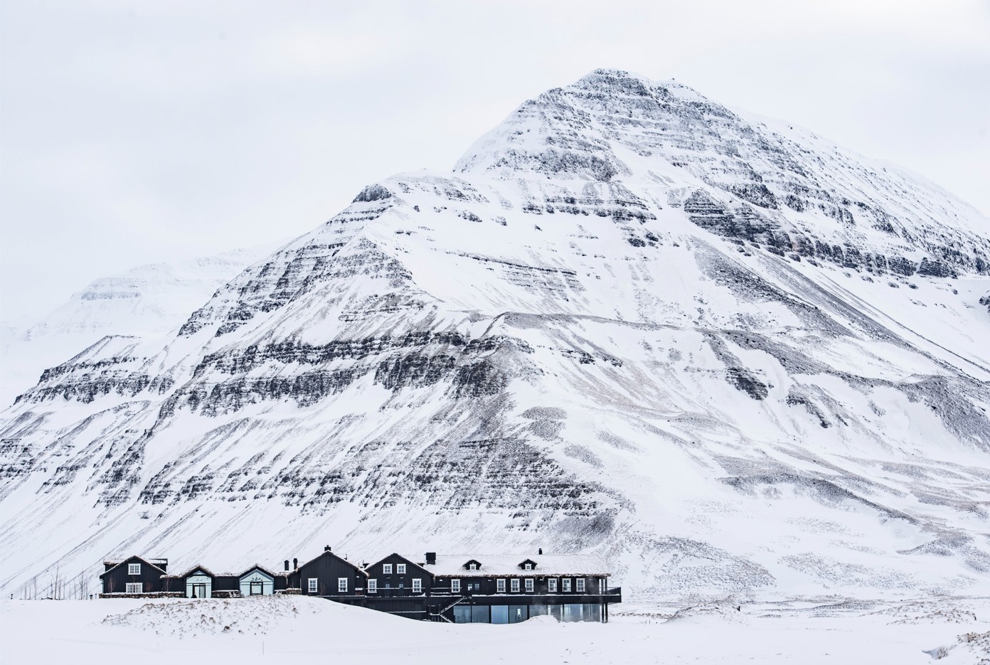 Deplar Farm covered in snow with a mountain behind it.